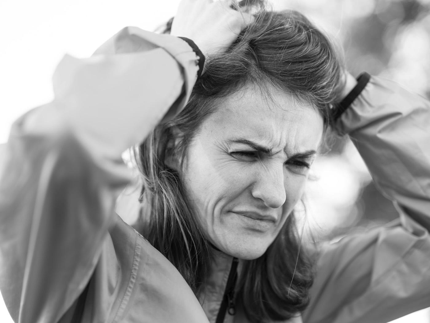 A woman in sportswear holds her head in pain